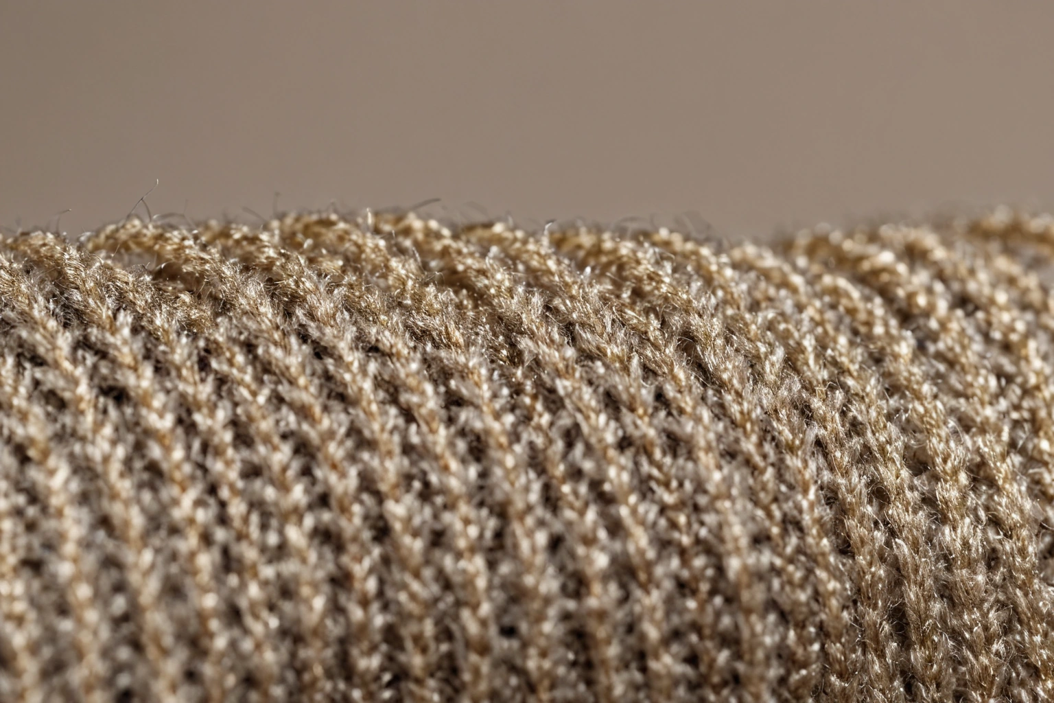 Macro photograph of pale boucl&eacute; fabric with fine metallic thread running through the looped surface